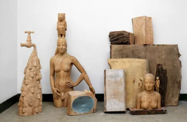 Various wooden sculptures against a wall.